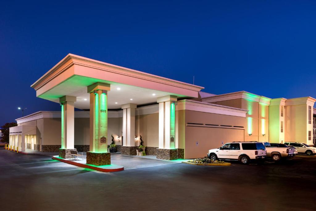 um grande edifício com um carro estacionado num parque de estacionamento em Holiday Inn Hotel & Suites Oklahoma City North, an IHG Hotel em Oklahoma City