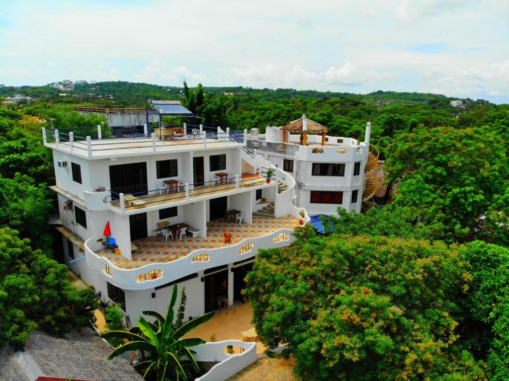 ein großes weißes Gebäude inmitten von Bäumen in der Unterkunft Aquarius Terraces Boutique Resort in Boracay