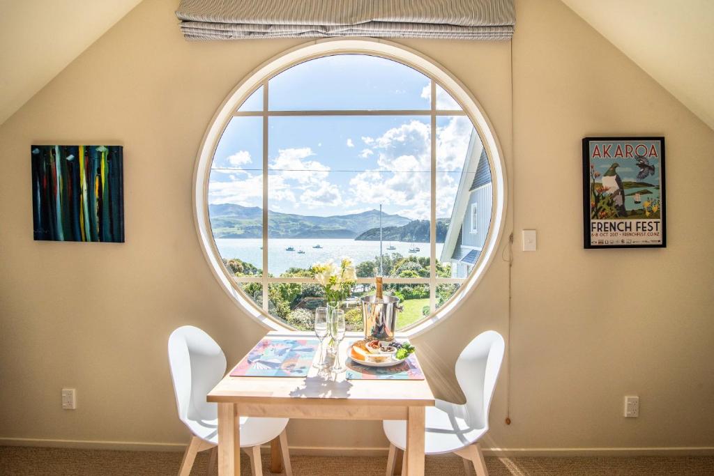 a dining room with a table and a large window at The Boathouse - Akaroa Holiday Home in Akaroa