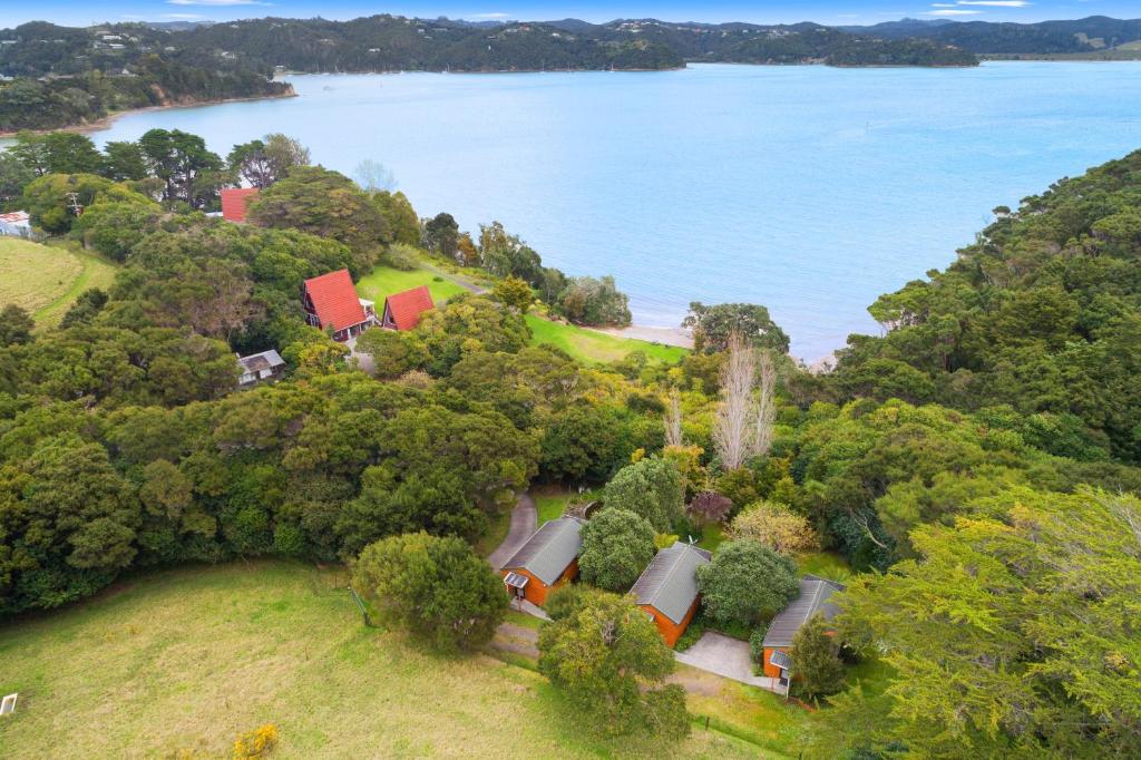 een uitzicht over een huis op een heuvel bij het water bij The Stables Wairoro Park - Russell Holiday Home in Russell