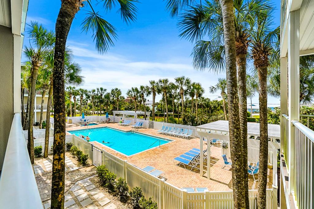 a view of a pool and palm trees from a balcony at Gulf Place Caribbean in Santa Rosa Beach