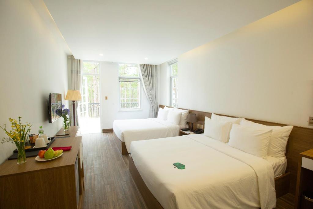 Postel nebo postele na pokoji v ubytování CEREJA Hotel & Resort Dalat