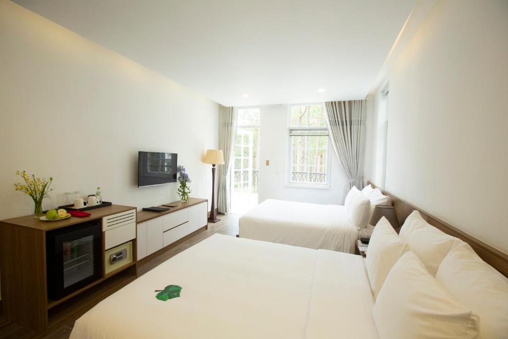 Postel nebo postele na pokoji v ubytování CEREJA Hotel & Resort Dalat