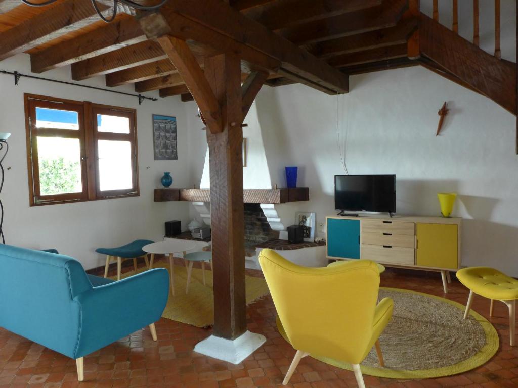 sala de estar con sillas, mesa y TV en Réf 227 Seignosse , à proximité immédiate de la plage des Bourdaines , villa patio classée 3 étoiles , 6 personnes, en Seignosse