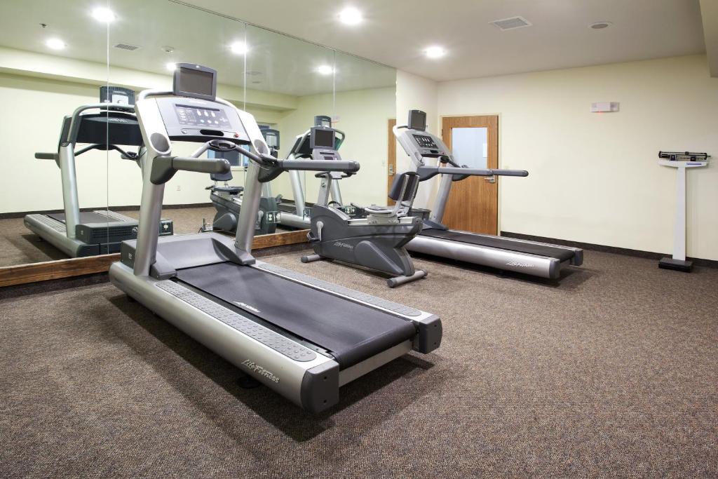 a gym with several tread machines in a room at Holiday Inn Express Hotel & Suites Torrington by IHG in Torrington