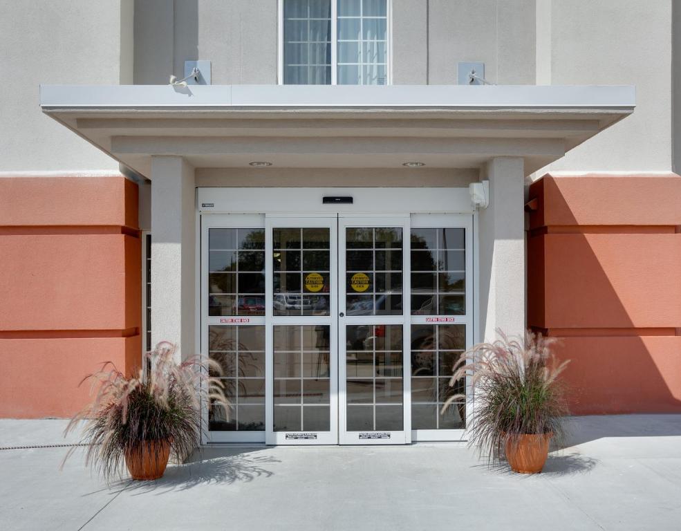 uma porta da frente de um edifício com dois vasos de plantas em Candlewood Suites Salina, an IHG Hotel em Salina