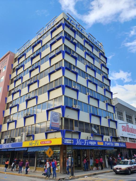 a tall building with people standing outside of it at Hotel Cristal in Poza Rica de Hidalgo