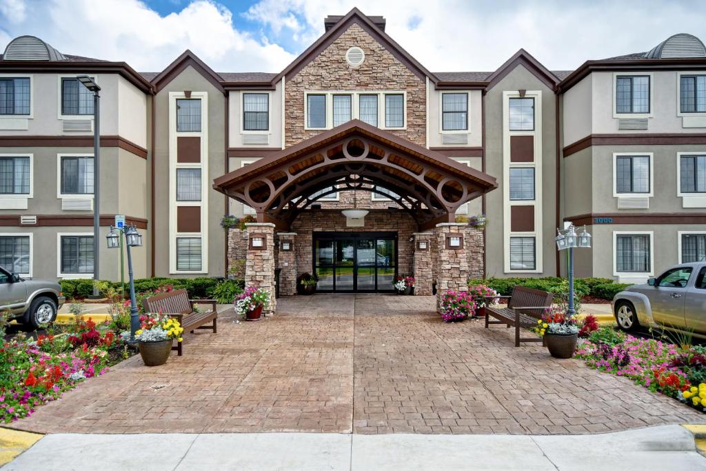 un accès à un bâtiment avec des bancs et des fleurs dans l'établissement Staybridge Suites Grand Rapids-Kentwood, an IHG Hotel, à Grand Rapids