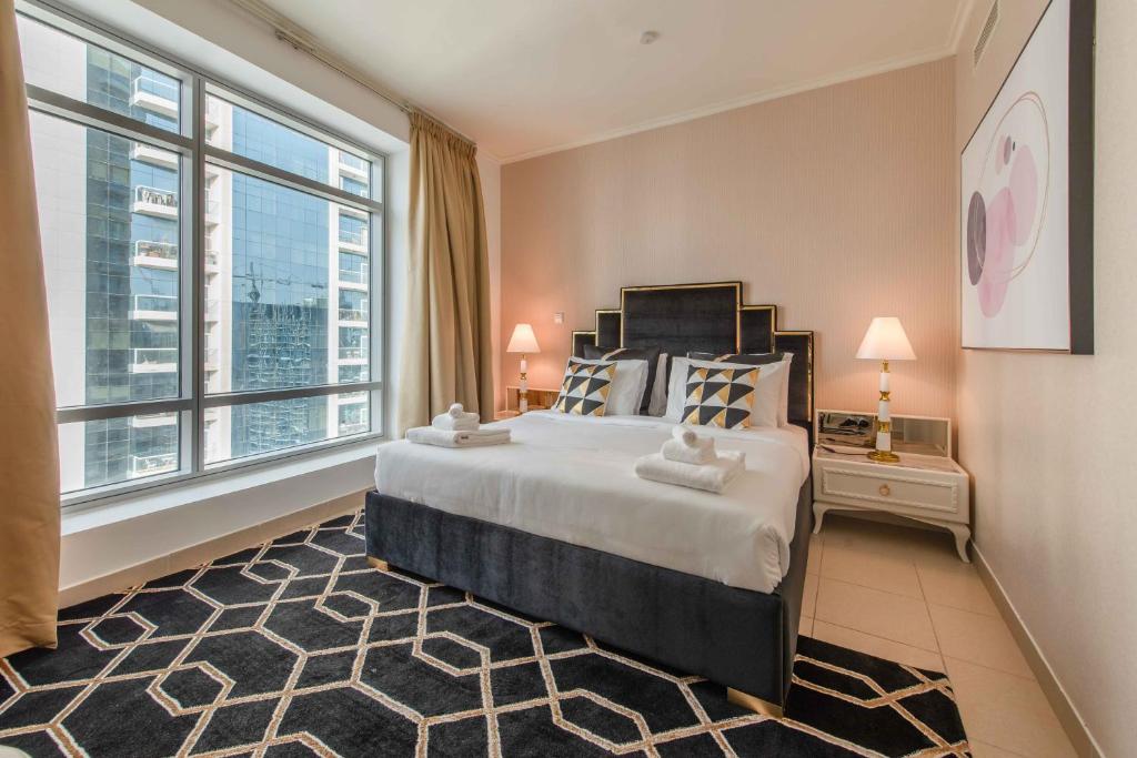 a bedroom with a large bed and large windows at BellaVista Burj Views Tower Opposite Dubai Mall in Dubai