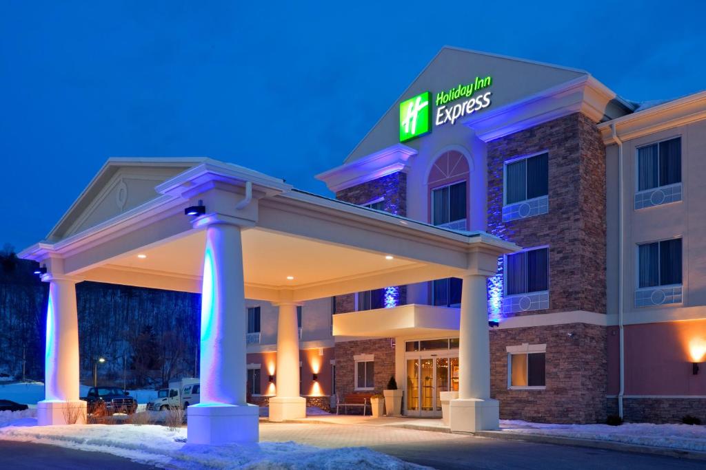 a hotel with a lit up sign in the snow at Holiday Inn Express Hotel & Suites West Coxsackie, an IHG Hotel in West Coxsackie