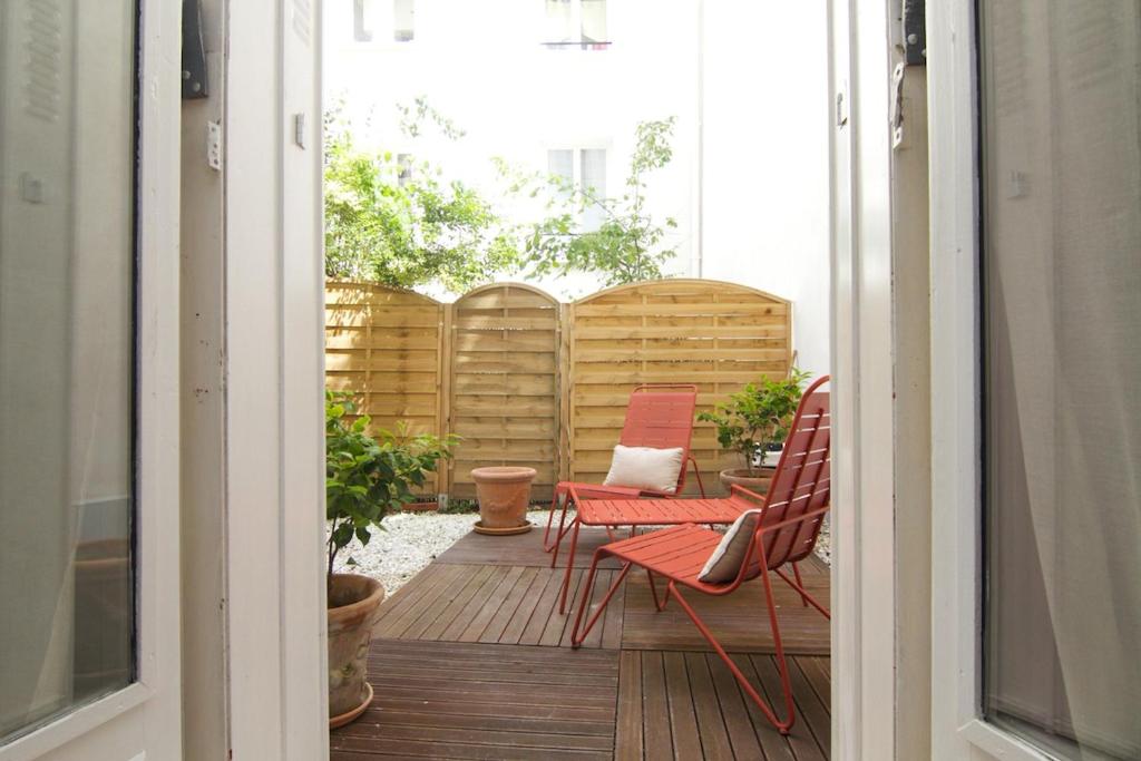 d'un balcon avec des chaises rouges, une table et des chaises. dans l'établissement Studio Montonnerre avec terrasse proche Necker et Montparnasse, à Paris