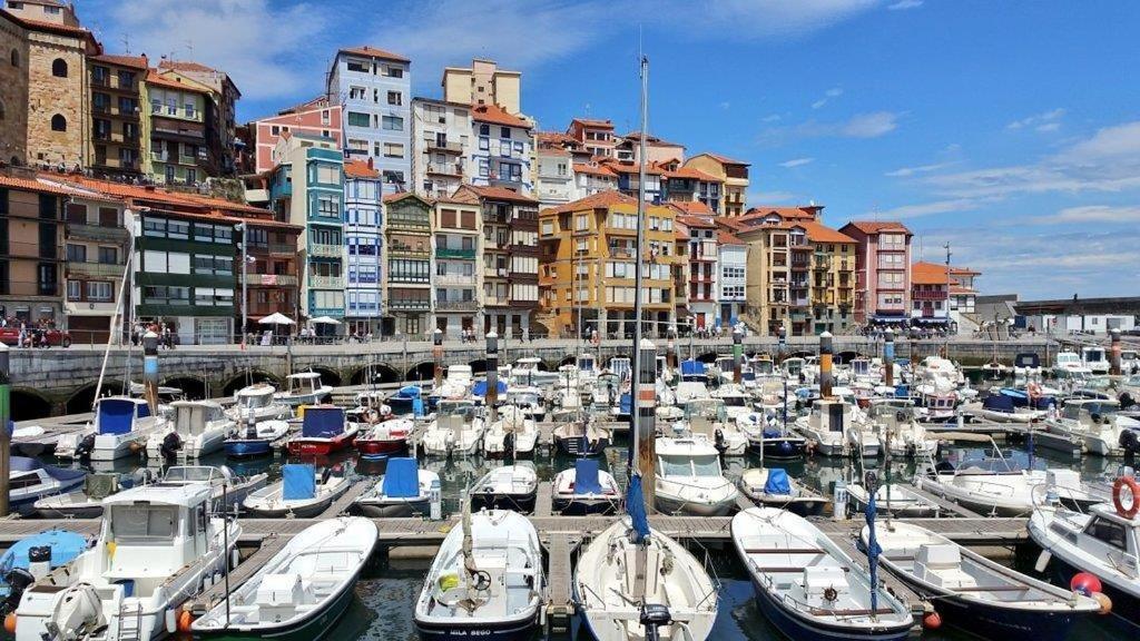 Un montón de barcos atracados en un puerto con edificios en Sare Enea, en Bermeo