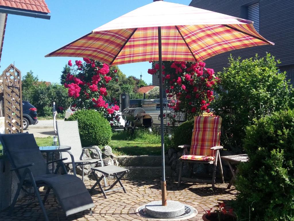 een patio met een parasol en een stoel bij Haus Marianne in Schafstedt