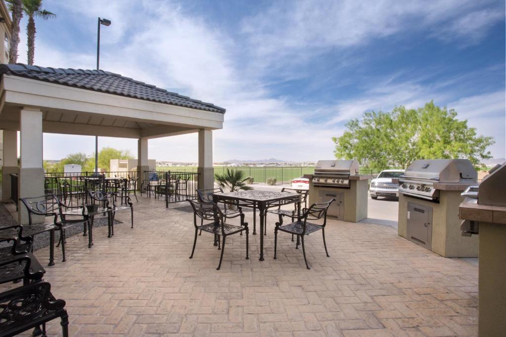 a patio with tables and chairs and a grill at Candlewood Suites Yuma, an IHG Hotel in Yuma