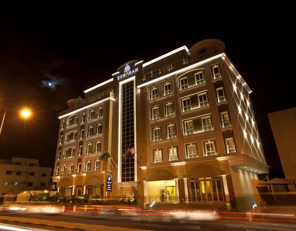 un edificio con luces por la noche en Zubarah Hotel, en Doha