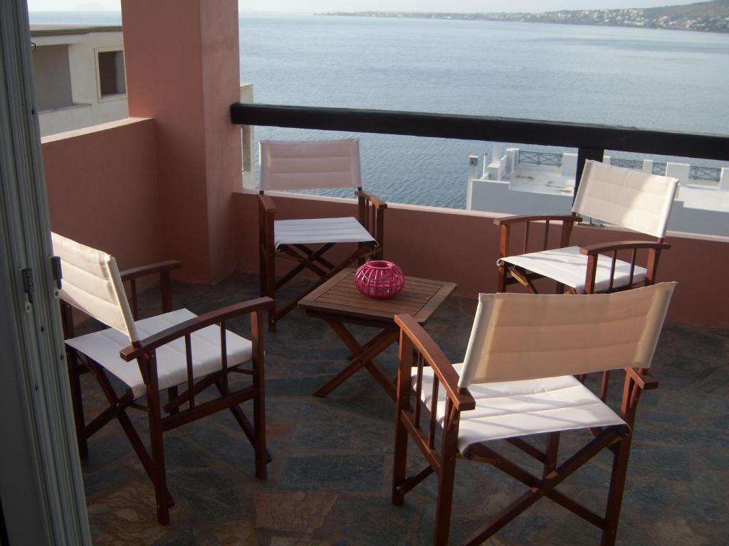 a group of chairs and tables on a balcony at Calma in Perdika