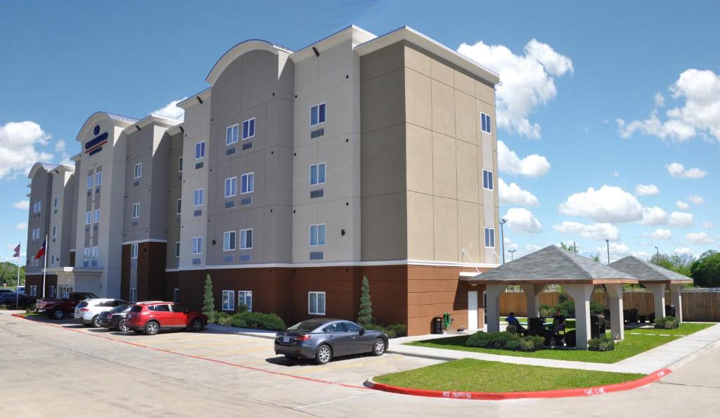 un grande edificio con auto parcheggiate in un parcheggio di Candlewood Suites Bay City, an IHG Hotel a Bay City