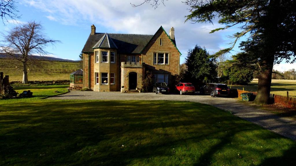 ein großes Backsteinhaus mit großem Hof in der Unterkunft Kiltearn Guest House in Evanton