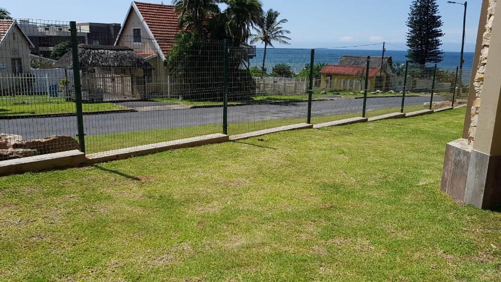 a fence in a yard next to a street at Saints View Resort Unit 6 in Uvongo Beach