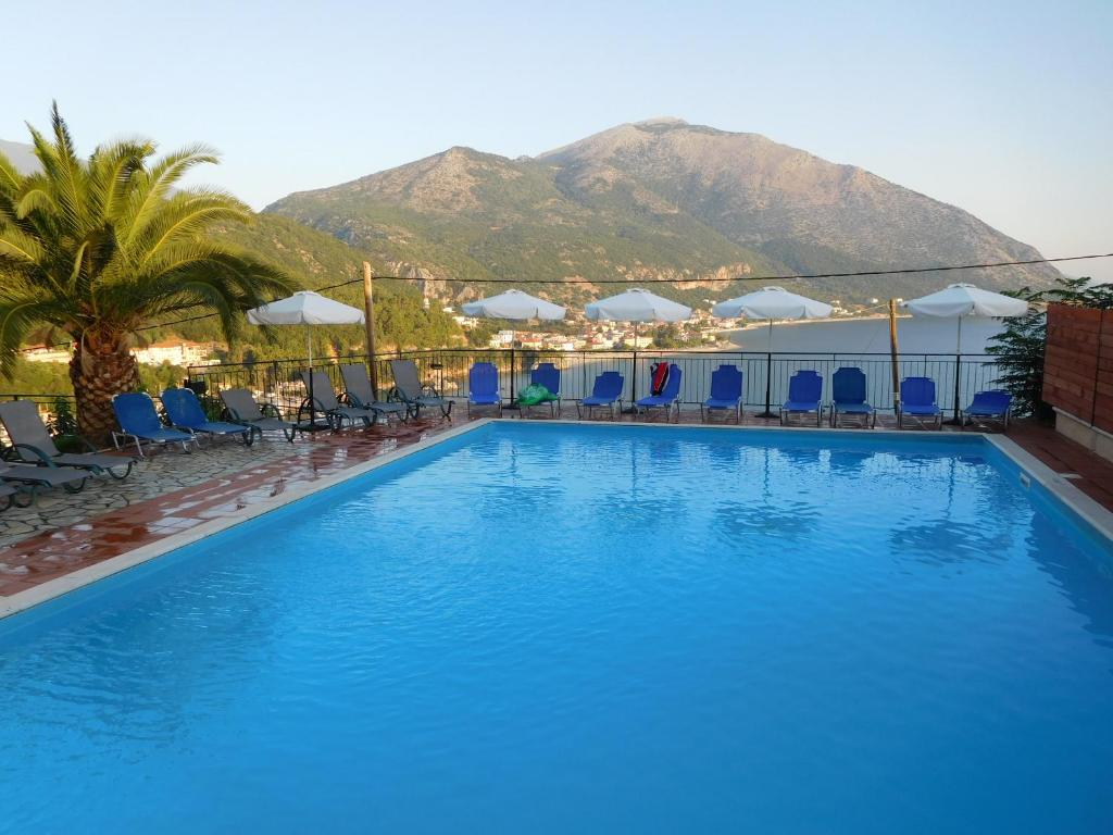 una grande piscina con una montagna sullo sfondo di Hotel Oceanis a Póros