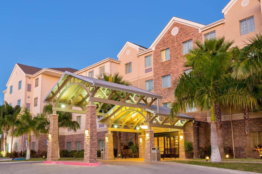 budynek z palmami przed nim w obiekcie Staybridge Suites McAllen, an IHG Hotel w mieście McAllen