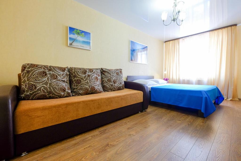 a living room with a couch and a bed at OK! Советская, 69 №9 in Tomsk