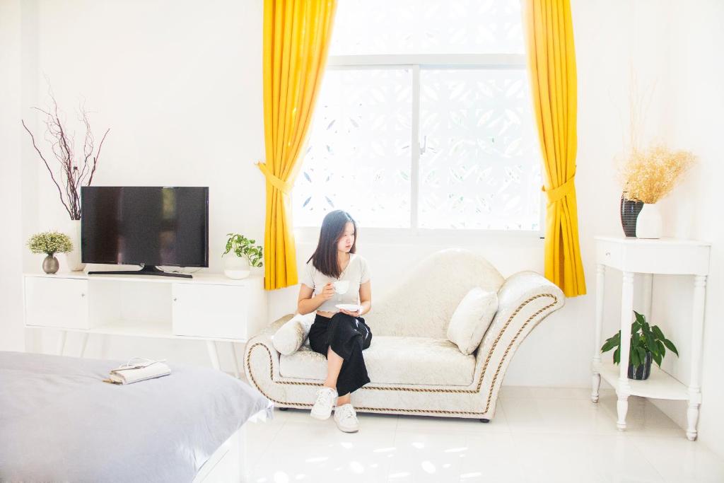 una mujer sentada en una silla en una habitación en MIDMOST Villa Hotel en Can Tho