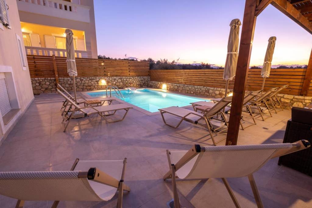 patio z krzesłami i basenem w obiekcie Prinos Oasis Twin Villas II w mieście Prínos