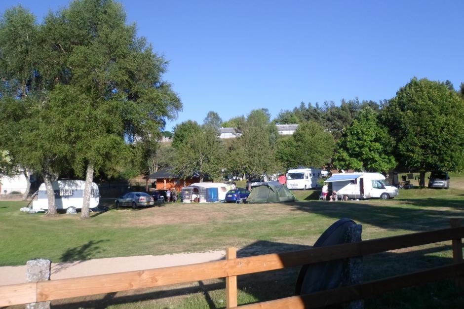 grupa namiotów i samochodów zaparkowanych w parku w obiekcie Camping Chez Prosper w mieście Fournels