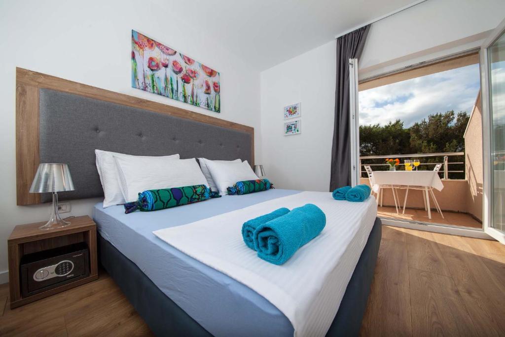 1 dormitorio con 1 cama grande y toallas azules. en Pansion Mlikota, en Promajna