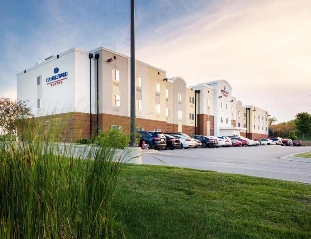 a building with a car dealership in a parking lot at Candlewood Suites Bellevue by IHG in Bellevue