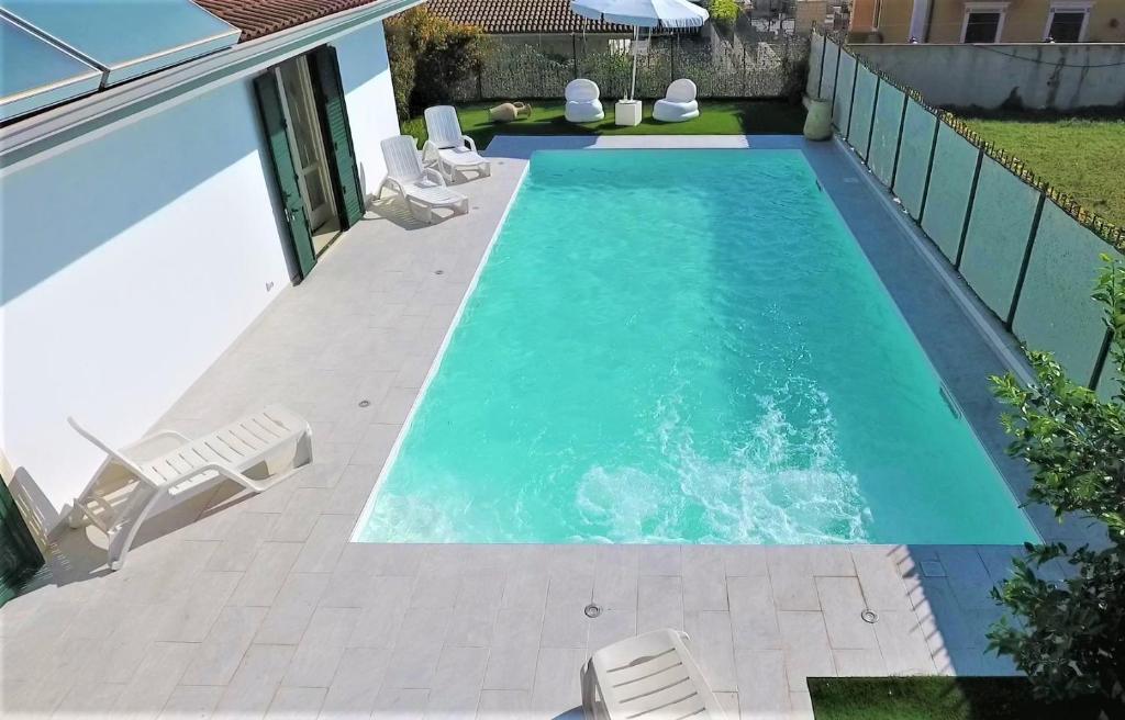 una piscina con due sedie a sdraio e una piscina di Villa Pantarei a Pozzallo