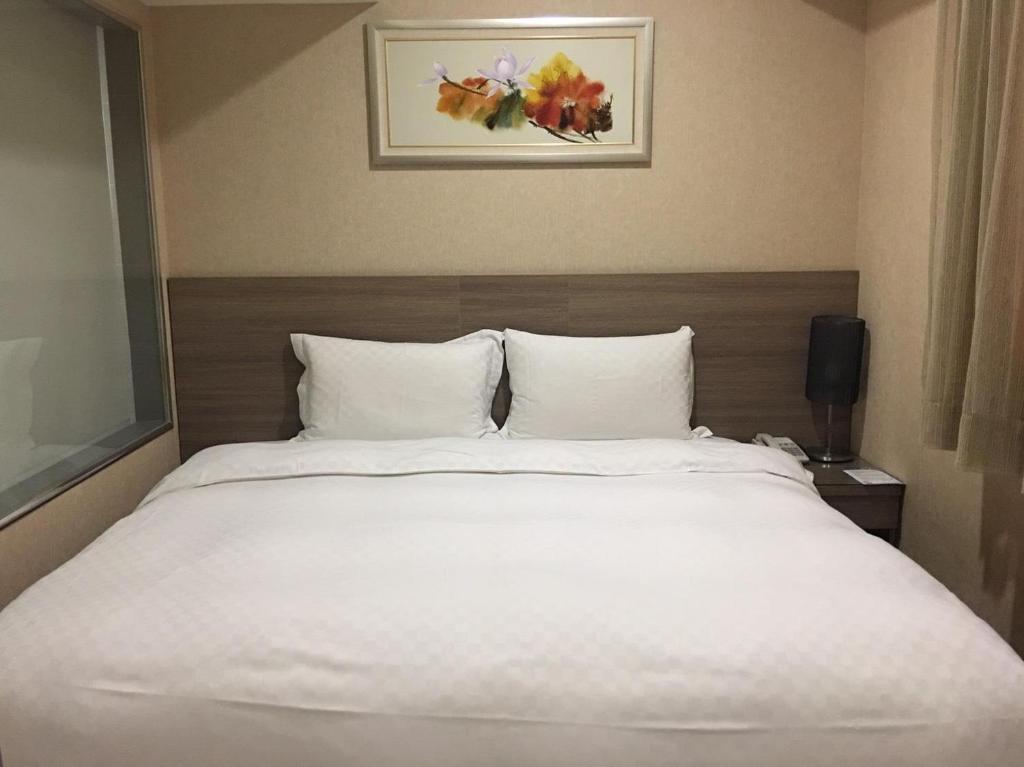 台中市にあるThe Metro Hotel Taichungのホテルルーム内の大きな白いベッド
