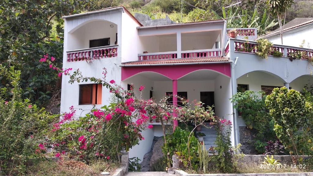 una casa con flores rosas delante de ella en Damontanha 2, en Ribeira Grande