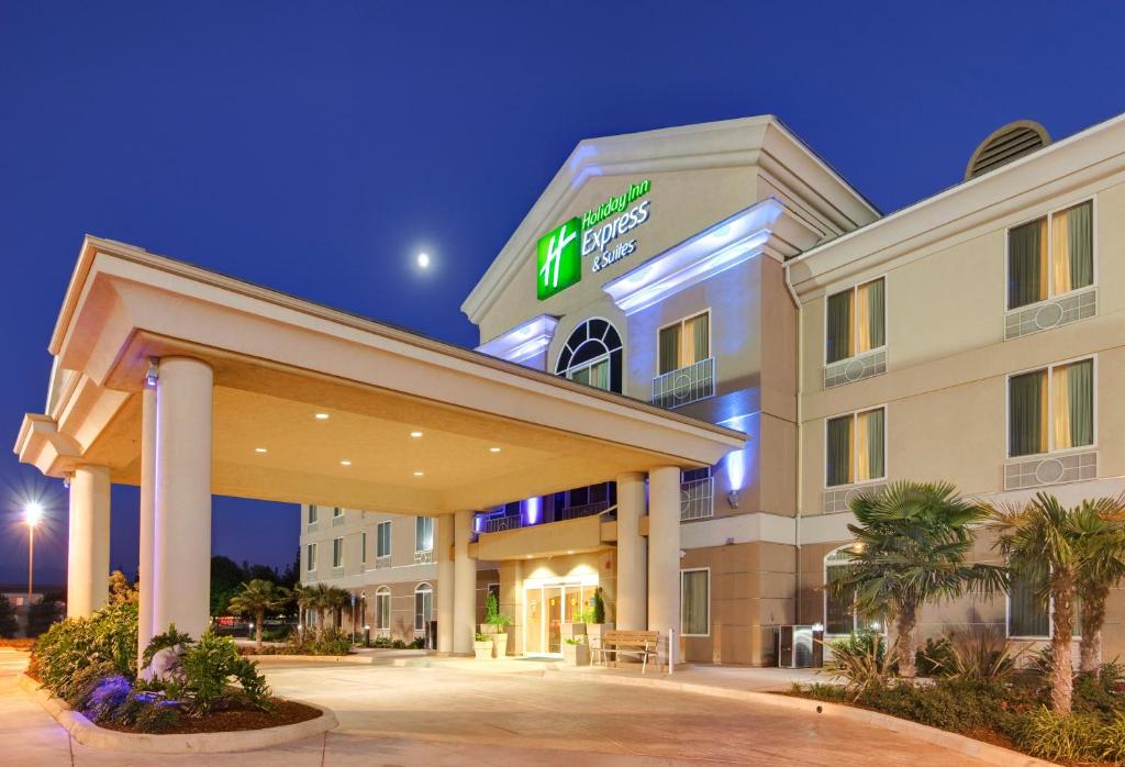 ポータービルにあるHoliday Inn Express Porterville, an IHG Hotelの夜間の看板が貼られたホテルの建物