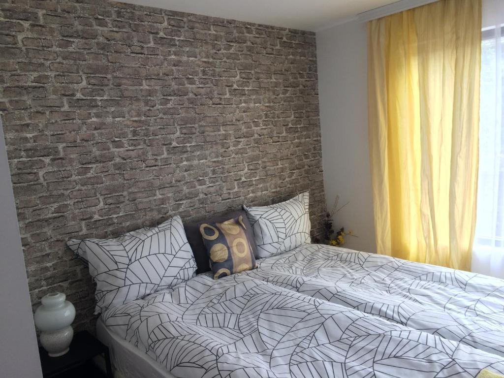 a bedroom with a brick wall and a bed at Guest House KN Malusha in Gabrovo