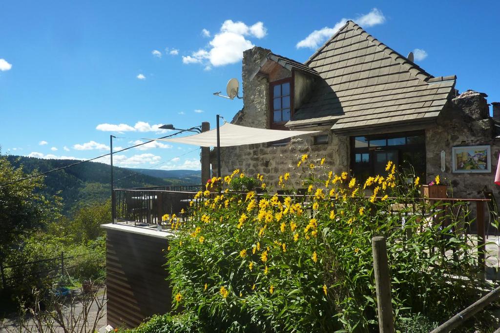 una casa en una colina con flores en primer plano en La Bergerie du Plateau, en Cros-de-Géorand