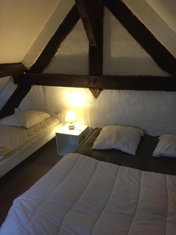 a attic bedroom with two beds and a lamp at haras de la Cère et ses chevaux in Polminhac