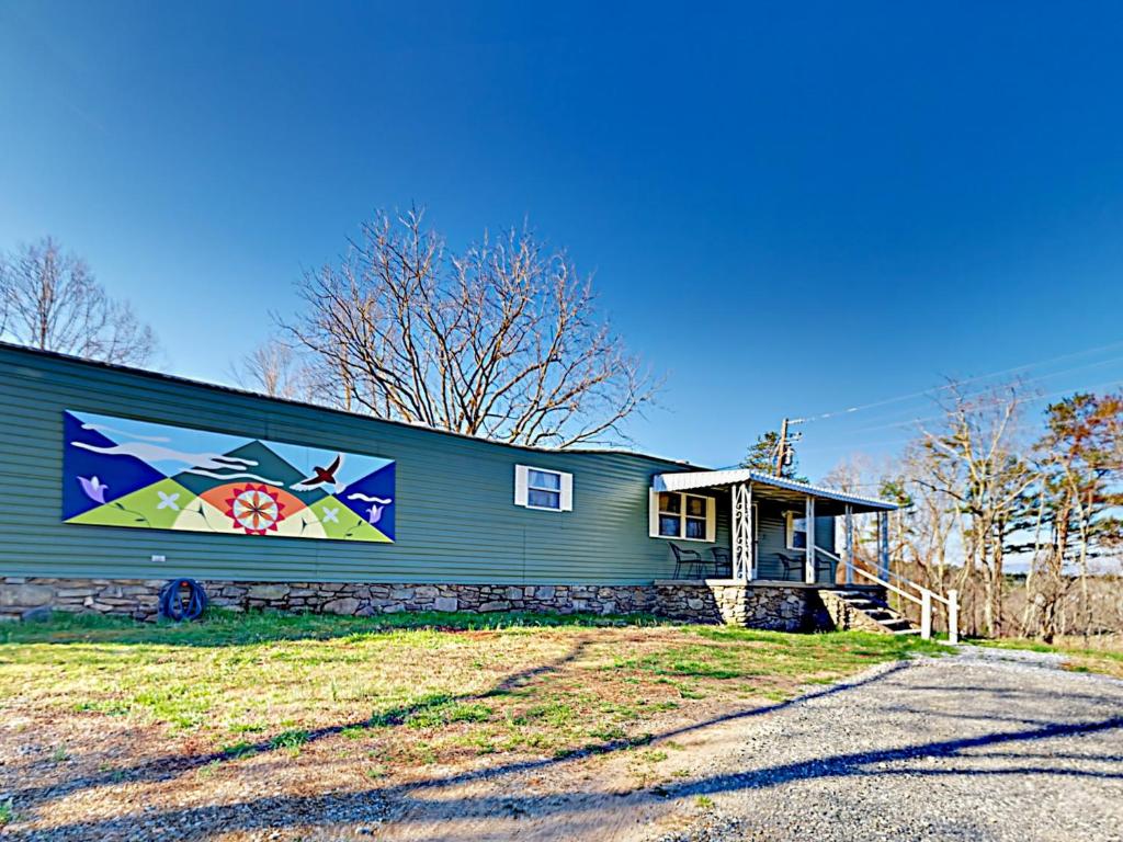 ein Haus mit einem Gemälde auf der Seite in der Unterkunft Serenity Views Bungalow - Close to City and Parkway! in Weaverville
