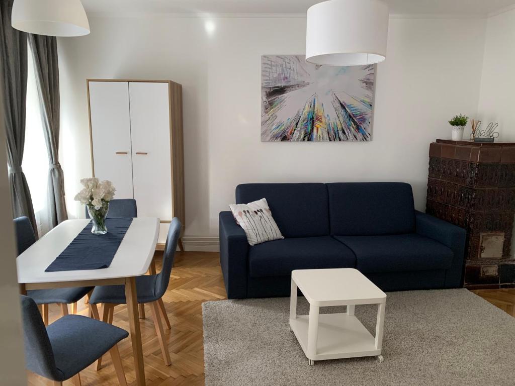 ein Wohnzimmer mit einem blauen Sofa und einem Tisch in der Unterkunft Apartmani SB 42 in Zagreb