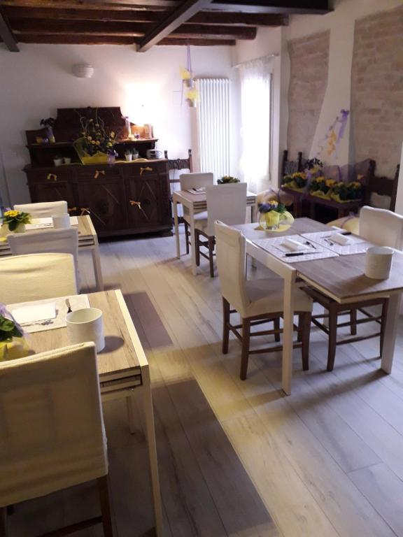 a dining room with tables and chairs and a kitchen at La Corte di Rosa in San Vito al Tagliamento
