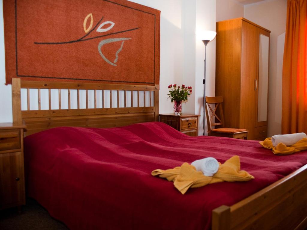 プラハにあるペンション　エウロパのベッドルーム1室(大型赤いベッド1台、タオル付)