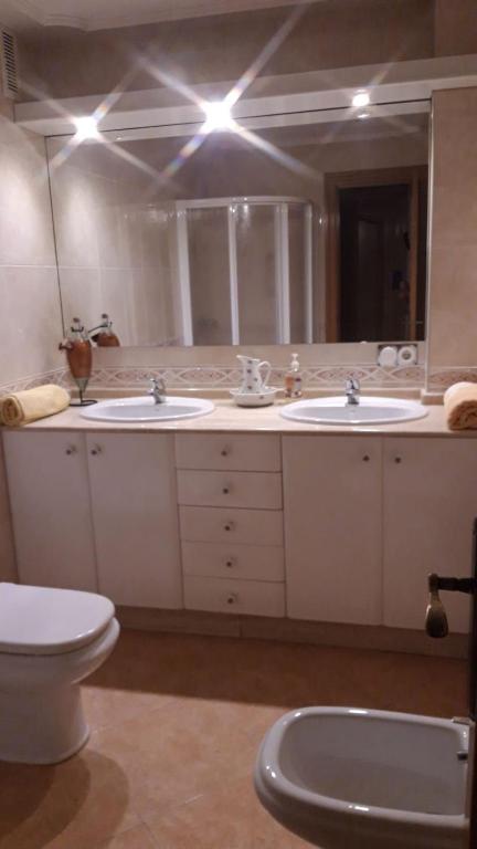 łazienka z 2 umywalkami, toaletą i lustrem w obiekcie La Conchita w mieście Almería