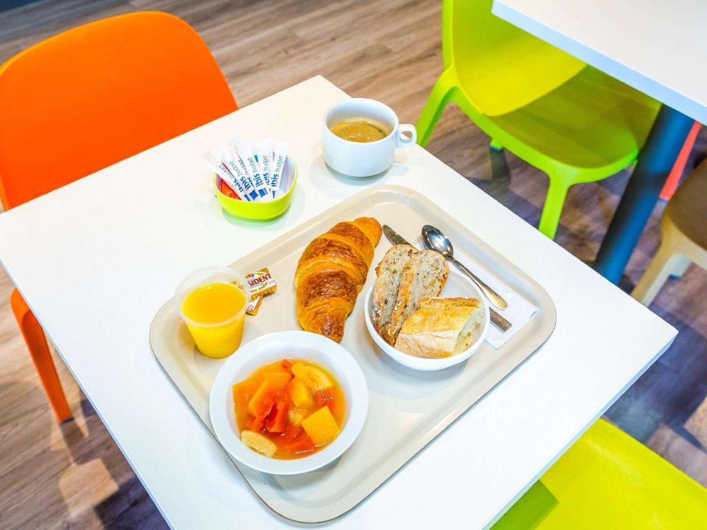 uma bandeja de comida com pão e fruta numa mesa em ibis budget Toulouse Colomiers em Colomiers