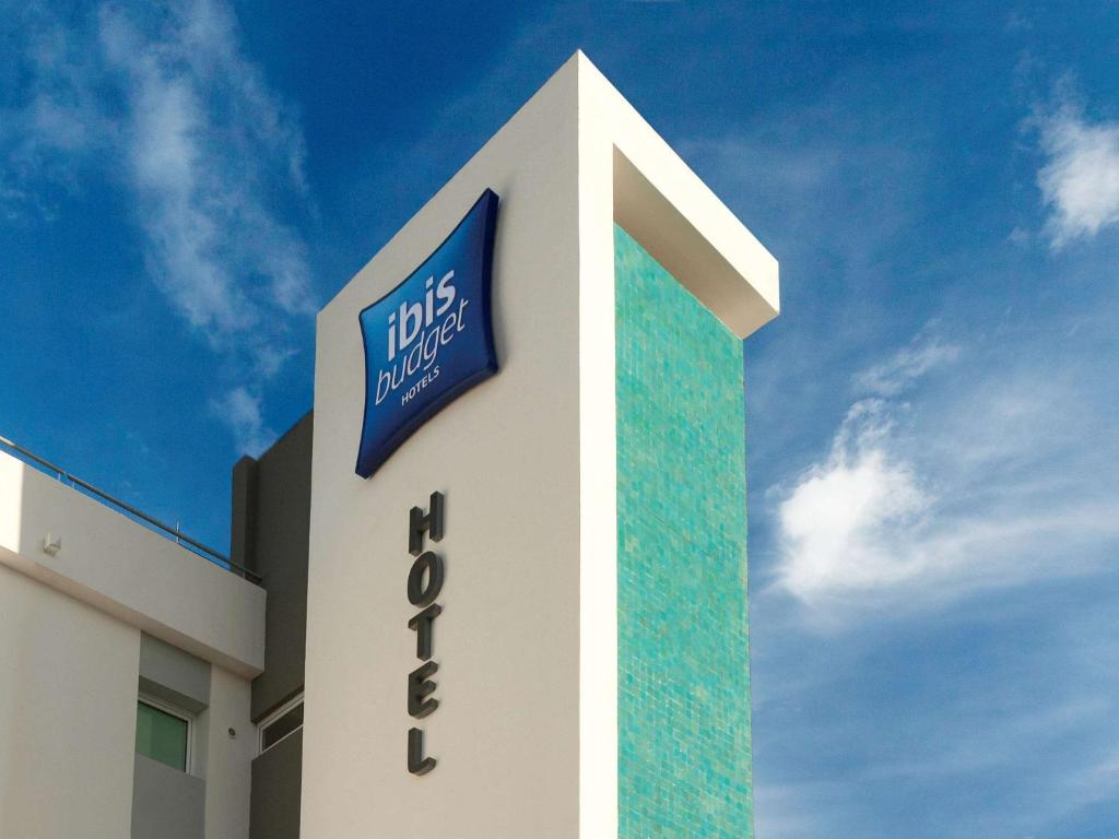 a building with a sign on the side of it at Ibis budget Dunkerque Grande Synthe in Grande-Synthe