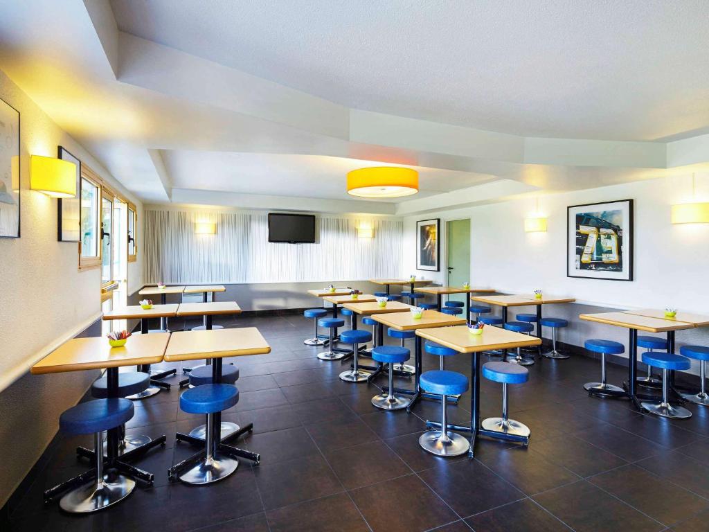 a classroom with tables and stools in a room at ibis budget Chartres in Chartres