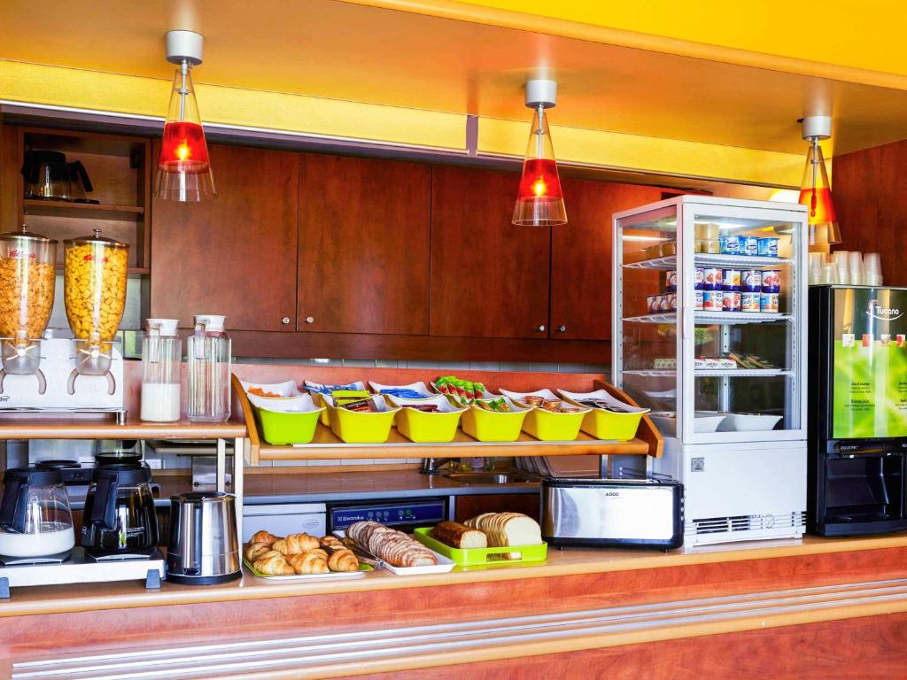 a kitchen with a counter with food and a refrigerator at ibis budget Chartres in Chartres