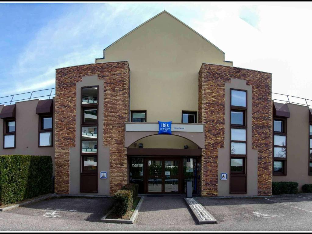 a large brick building with a large doorway at ibis budget Annemasse Geneve in Annemasse