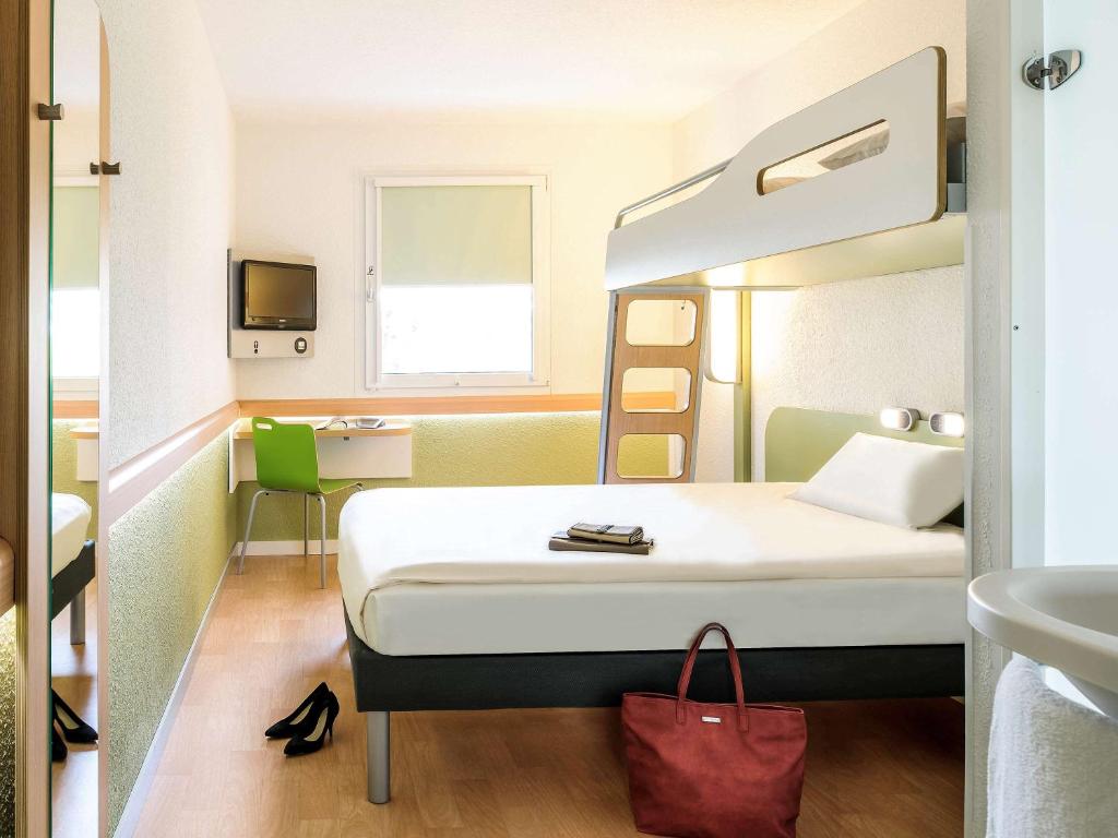 um quarto de hotel com uma cama e um lavatório em Ibis budget Lille Ronchin - Stade Pierre Mauroy em Ronchin