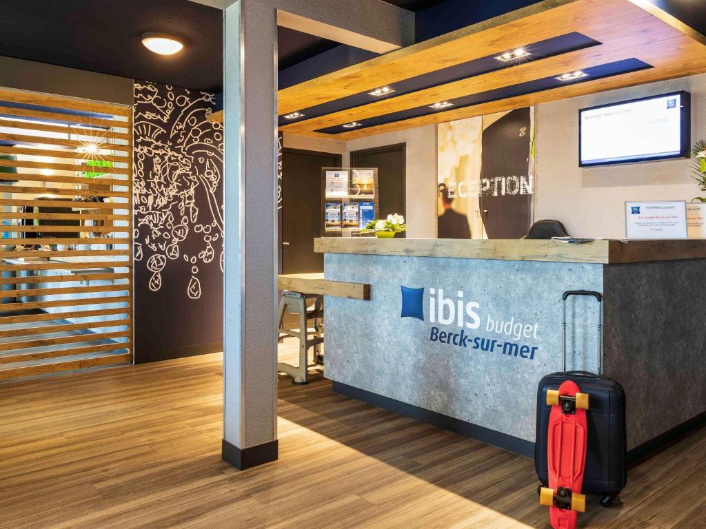 a suitcase is sitting in front of a restaurant counter at ibis budget Berck Sur Mer in Berck-sur-Mer